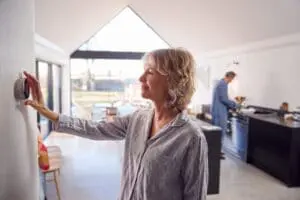 Oman Adjusting Her Wall Mounted Thermostat