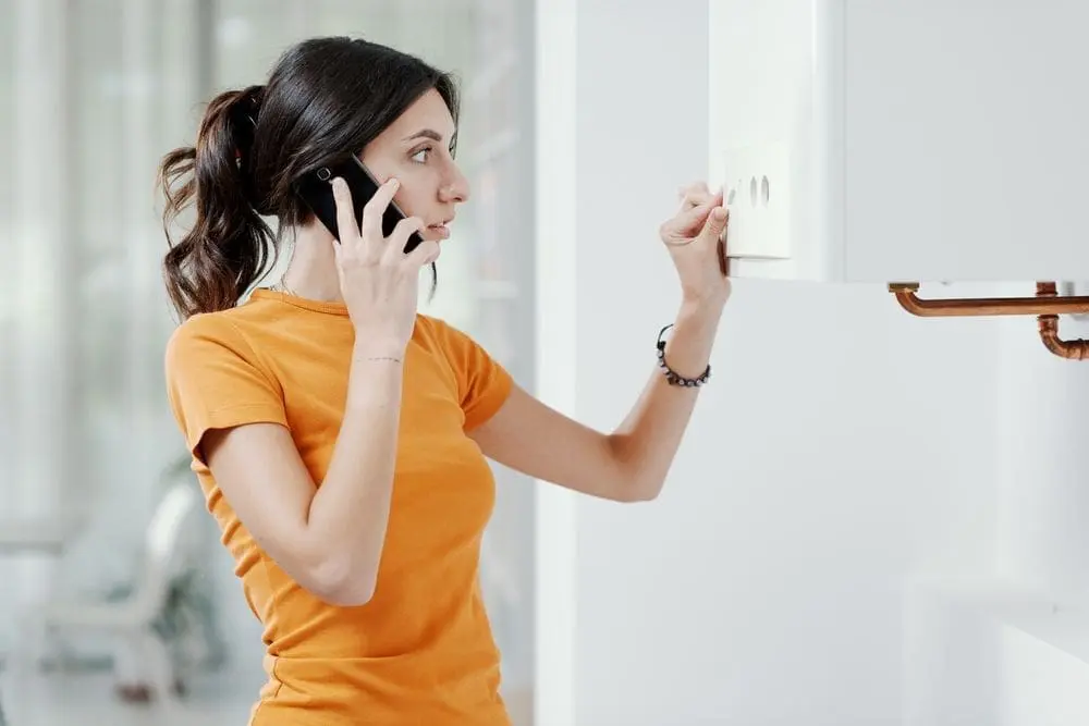 woman adjusting thermostat