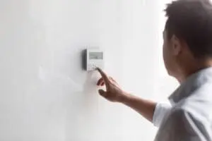 FAQs - Ambient Edge man adjusting air conditioner control panel
