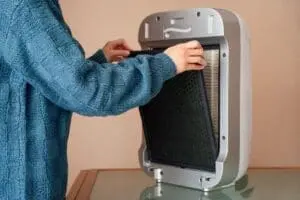 FAQs - Ambient Edge person changing filter in portable air conditioner