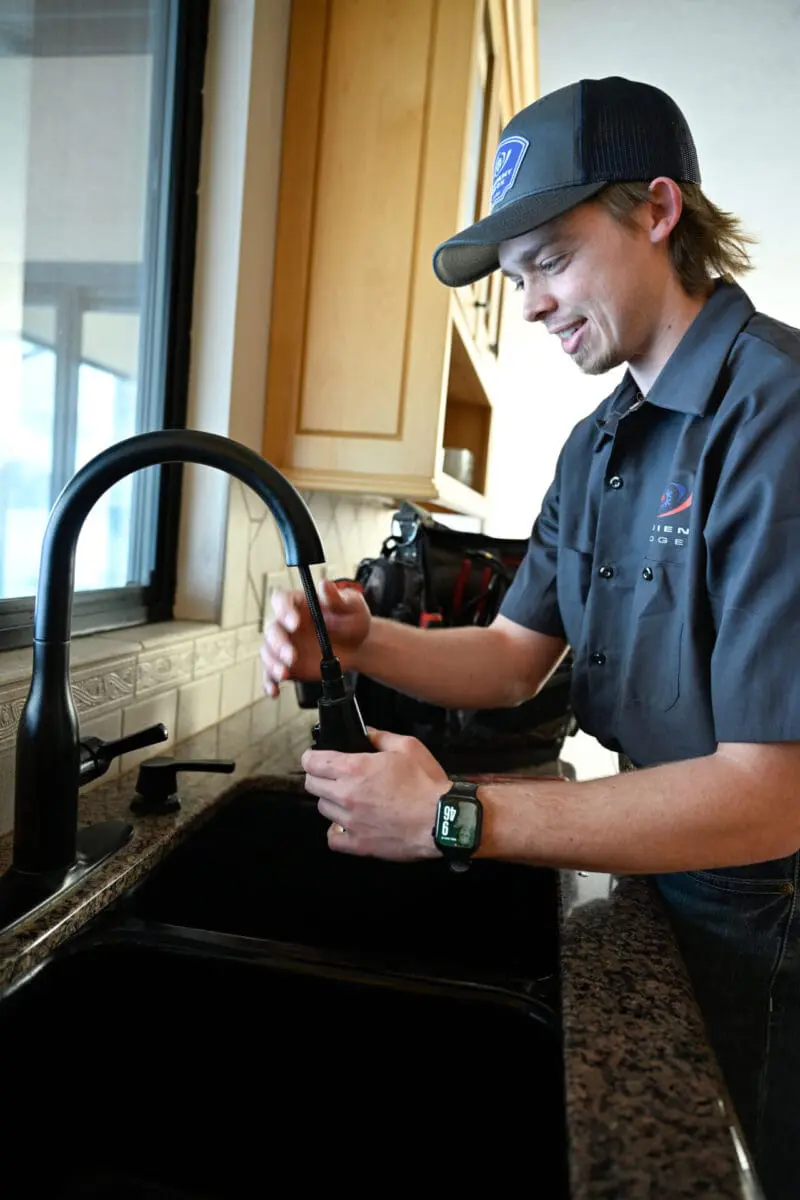 ambient edge plumber working on a faucet