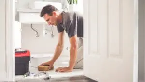 person sponging up water in the bathroom