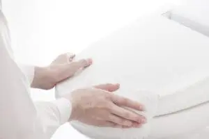 person cleaning a toilet lid