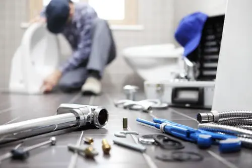 tools on ground with a plumber in the background