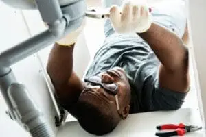 plumber underneath a sink