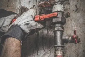 person unscrewing a pipe