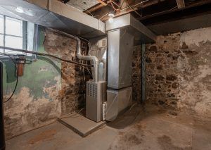 old furnace in corner of basement