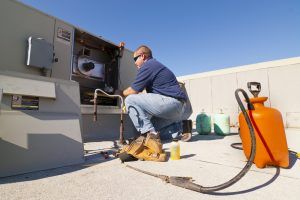 a technician repairs a facility’s AC unit