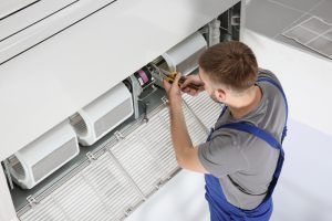technician finishes commercial ac unit replacement