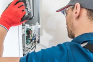 technician fixing central home furnace.