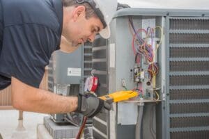 technician performs test on ac unit