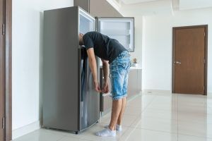 man with head in freezer on hot day