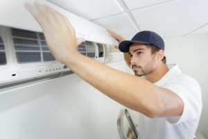 technician finishes installing residential ac unit