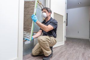 technician replaces HVAC system air filter