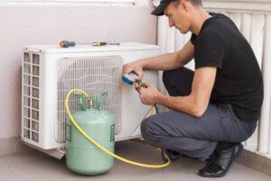 air-conditioner-repairman-fixing-freon-leak