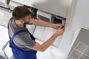 male technician repairing air conditioner 