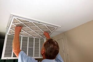 man maintaining indoor air conditioner