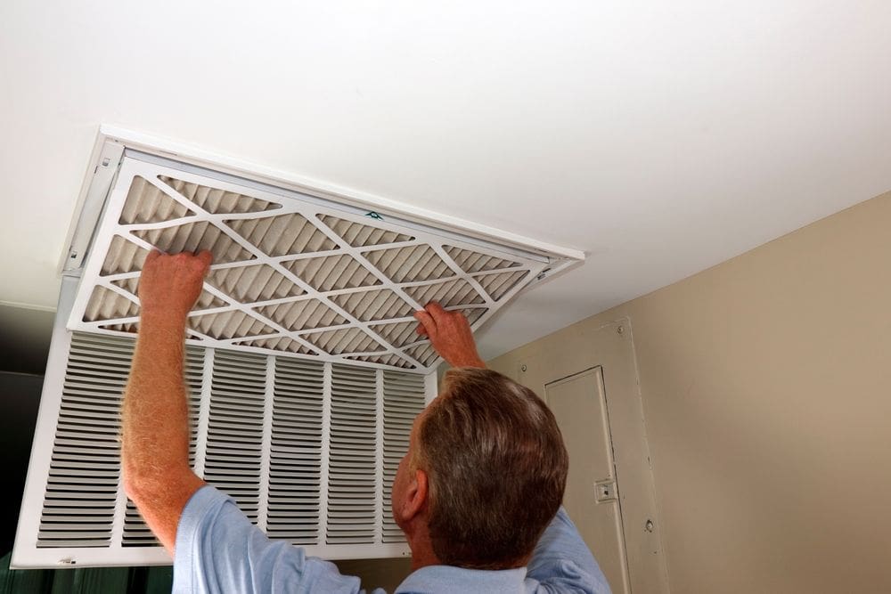 man maintaining indoor air conditioner