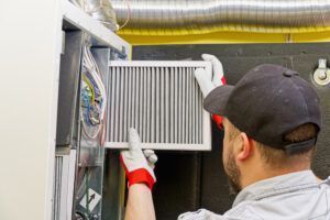 hvac service technician changing dirty air filter